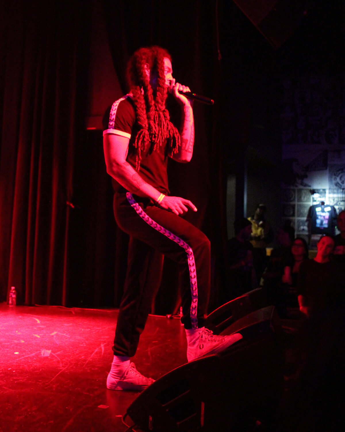 Vocalist performing on a small stage under red lights