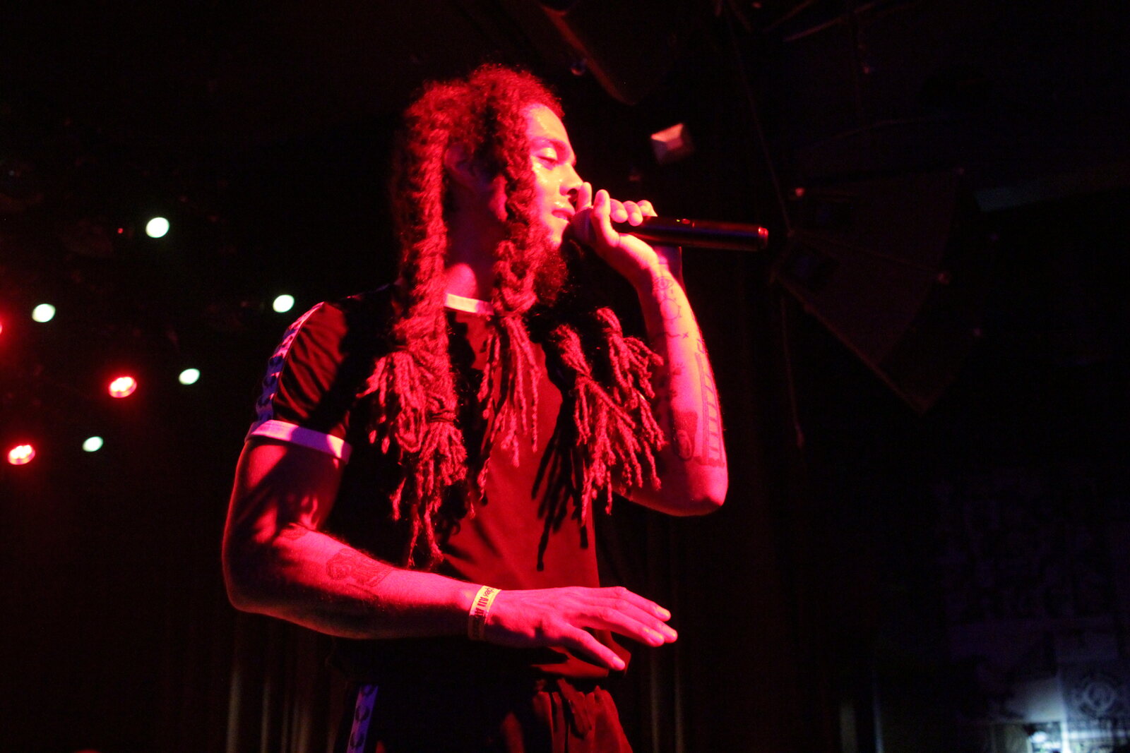 Close view of a singer performing in a dark club with red lighting