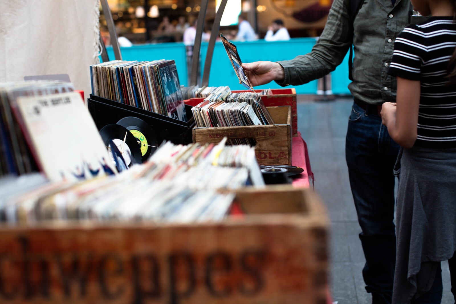 Hands browsing vinyl records at a merch or record table